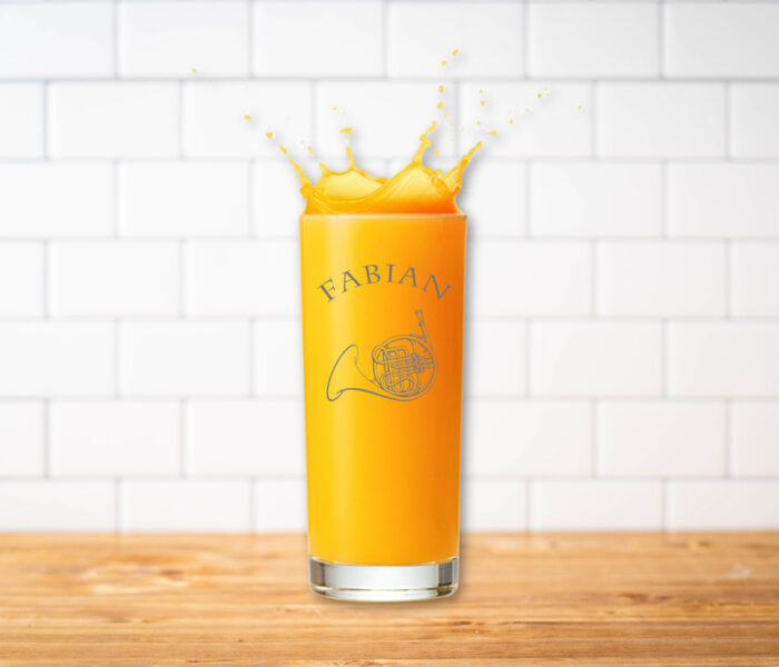 Graviertes Glas mit Horn und Namen mit Orangensaft.