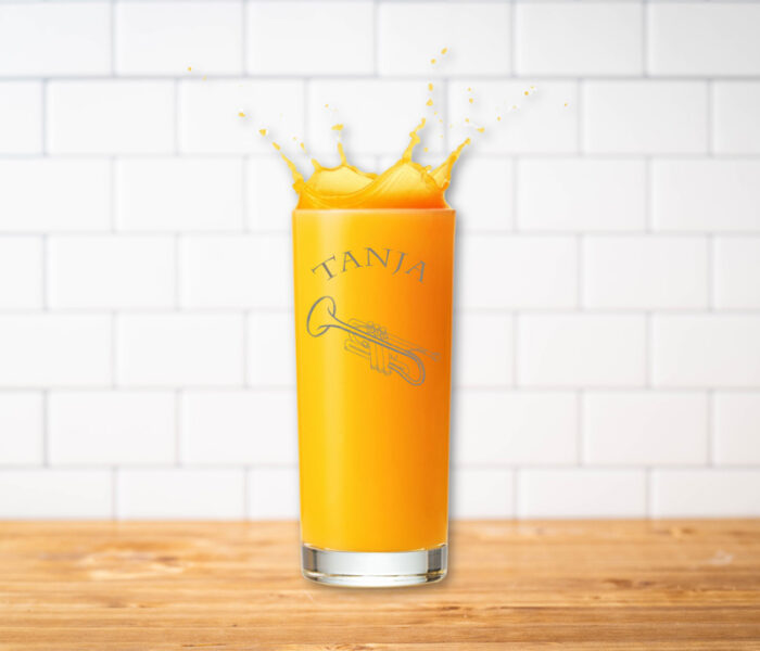 Glas mit Gravur Trompete und Namen mit Orangensaft.
